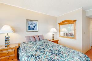 ein Schlafzimmer mit einem Bett, zwei Lampen und einem Spiegel in der Unterkunft Plaza 1404 in Ocean City + 19 Fotos