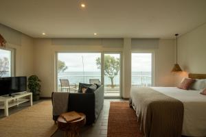 a bedroom with a bed and a couch and a television at Bay House in Ponta Delgada