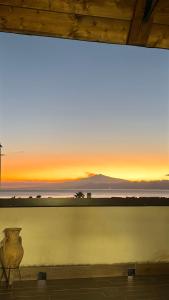 un coucher de soleil vu à travers une fenêtre avec un vase dans l'établissement Charm Airport, à Reggio de Calabre 44 autres photos