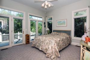 a bedroom with a large bed and windows at Moonrise Point in Edisto Island