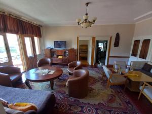 a living room with a couch and a table and chairs at **ETNO Vila** - KRUSEVO in Kruševo