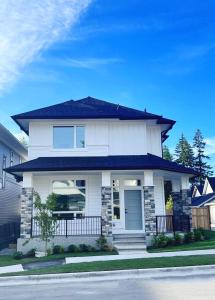 a white house with a blue roof at Kris Anclam in Langley