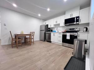 a kitchen with white cabinets and a table with chairs at Kris Anclam in Langley +6 photos