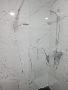 een badkamer met een douche en een marmeren muur bij Studio Luxe Nouaceur in Nouaseur