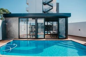 a house with a swimming pool and glass walls at Golf View Apartments in Maputo