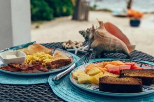 ein Tisch mit zwei Tellern Frühstücksprodukt drauf in der Unterkunft The Tropical Breeze Cottage in Sand Bluff + 33 Fotos