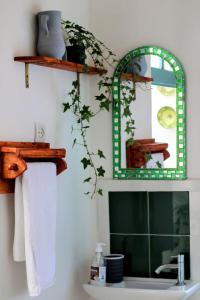 een badkamer met een groene spiegel en een wastafel bij Dar janna in Essaouira