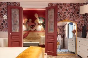 a bedroom with a painting on the wall and a mirror at Villa Emilia - Suites de prestige au coeur de Nancy in Nancy