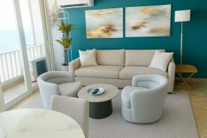 uma sala de estar com um sofá, cadeiras e uma mesa em Condado Beachfront- Perfect for Families! em San Juan
