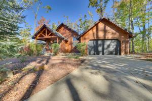 a log cabin in the woods with a driveway at Luxury Cabin in The Reserve at Boyne Mountain in Boyne Falls