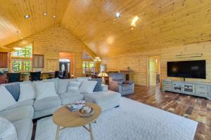 a living room with a white couch and a tv at Luxury Cabin in The Reserve at Boyne Mountain in Boyne Falls