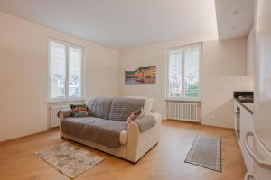 a living room with a couch and two windows at La Casa di Biancaneve in Recco