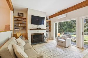 a living room with a fireplace and a tv at Topnotch 329E in Stowe Fork