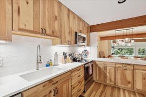 a kitchen with wooden cabinets and a white sink at Topnotch 329E in Stowe Fork