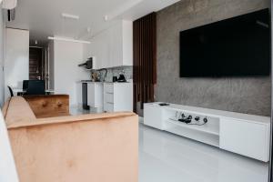 a living room with a couch and a tv on a wall at Golf View Apartments in Maputo