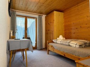 a bedroom with a bed and a table and a window at Appartement Heim in Sankt Gallenkirch
