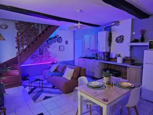 a kitchen and living room with a purple lighting at La Phyllade in Monthermé