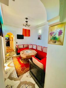 非斯Blue Star Hostel的客厅里有一张红色的沙发和一张桌子