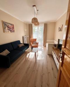 a living room with a blue couch and a table at Apartament Akacja CENTRUM in Rzeszów