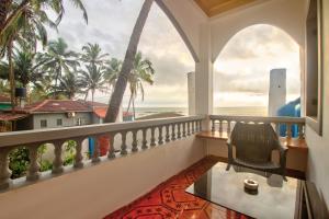 a room with a balcony with a view of the ocean at Anjuna House With Ocean View in Anjuna +14 photos