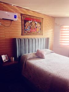 a bedroom with a bed and a painting on the wall at Hotel del valle in Melipilla