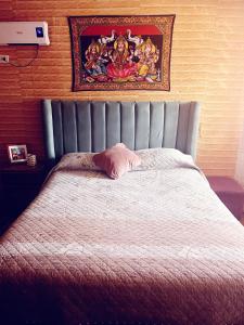 a bed in a bedroom with a painting on the wall at Hotel del valle in Melipilla