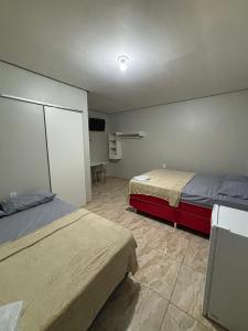 a room with two beds and a tv in it at Pousada Luz do Norte in Macapá