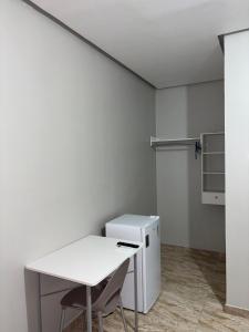 a white room with a table and a refrigerator at Pousada Luz do Norte in Macapá +21 photos
