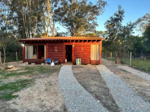 a small wooden cabin with a pathway leading to it at Macondo in Sauce de Portezuelo