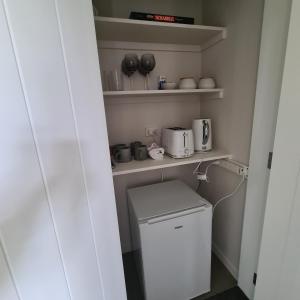 a small laundry room with a washer and dryer at Sandspit Hideaway in Sandspit