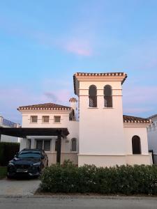 ein schwarzes Auto, das vor einem Haus geparkt ist in der Unterkunft Villa Marrajo La Torre Golf Resort in Torre-Pacheco