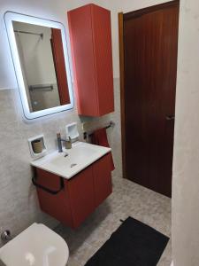 Un baño con inodoro, lavabo y espejo. en Rooms Franca la Sarta, en Castellana Grotte