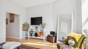 a living room with a couch and a tv at Elegant Escape Minutes from Downtown & UIC in Chicago