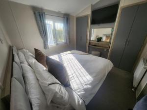 a bedroom with a large white bed with pillows at Hot tub lodge grange leisure park Mablethorpe in Mablethorpe +5 photos