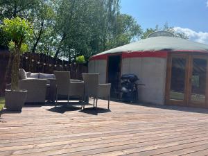 a gazebo with chairs and a table on a deck at Jurta Leśne Zacisze StOdOlNiA 