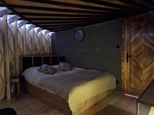 a bedroom with a bed with a clock on the wall at Jurta Leśne Zacisze StOdOlNiA 