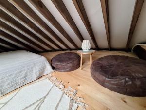 a room with a bed and two ottomans and a table at Jurta Leśne Zacisze StOdOlNiA  +25 photos