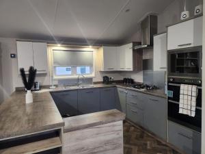 a kitchen with white cabinets and a counter top at Hot tub lodge grange leisure park Mablethorpe in Mablethorpe