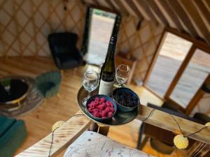 a table with a bottle of wine and wine glasses at Jurta Leśne Zacisze StOdOlNiA 