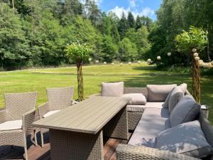 a patio with a wooden table and chairs at Jurta Leśne Zacisze StOdOlNiA 