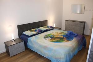 a bedroom with a large bed with a colorful blanket at Flamingo Houses in Quartu Sant'Elena