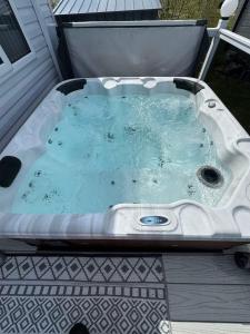 a jacuzzi tub sitting on a porch at Hot tub lodge grange leisure park Mablethorpe in Mablethorpe