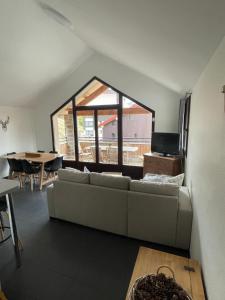 a living room with a couch and a large window at Star Résidence in Isola