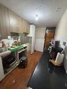 a kitchen with a long black counter in a kitchen at Hostel Wayra Wasi in Lima