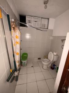 a bathroom with a toilet and a shower curtain at Hostel Wayra Wasi in Lima
