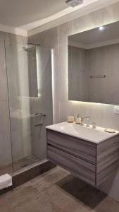 a bathroom with a sink and a shower with a mirror at Departamento 318 en complejo premiun de Pinamar Norte in Pinamar
