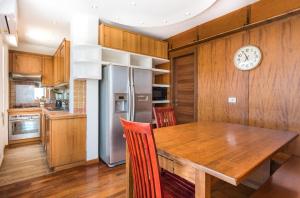 cocina con mesa de madera y reloj en la pared en Vatican-Metro A Panoramic Penthouse with Jacuzzi, en Roma