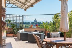 Un patio con mesas y sillas y vista a la ciudad. en Vatican-Metro A Panoramic Penthouse with Jacuzzi, en Roma