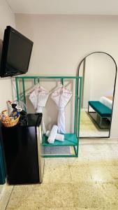 a room with a mirror and three shirts on hangers at Del Tropico hotel in Sopetran +22 photos