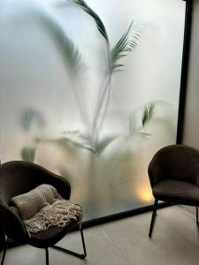 two chairs sitting in a room with a window at Exclusive Rainforest Villas in Tapantí +1 photo